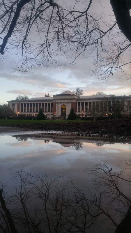 Image of Oregon State University's Memorial Union with the reflection from a puddle of water.